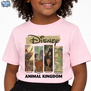 Peut inclure: T-shirt rose avec le logo Disney et des images de &laquo;&nbsp;Le Roi Lion&nbsp;&raquo;, &laquo;&nbsp;Tarzan&nbsp;&raquo;, &laquo;&nbsp;Fr&egrave;re des ours&nbsp;&raquo; et &laquo;&nbsp;Le Livre de la Jungle&nbsp;&raquo;. Les mots &laquo;&nbsp;Animal Kingdom&nbsp;&raquo; sont imprim&eacute;s en dessous.
