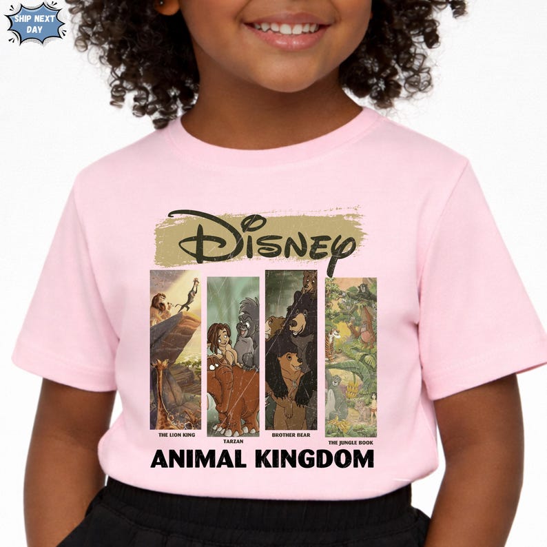 Peut inclure: T-shirt rose avec le logo Disney et des images de &laquo;&nbsp;Le Roi Lion&nbsp;&raquo;, &laquo;&nbsp;Tarzan&nbsp;&raquo;, &laquo;&nbsp;Fr&egrave;re des ours&nbsp;&raquo; et &laquo;&nbsp;Le Livre de la Jungle&nbsp;&raquo;. Les mots &laquo;&nbsp;Animal Kingdom&nbsp;&raquo; sont imprim&eacute;s en dessous.