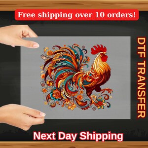 May include: A colorful rooster with intricate patterns and floral designs. The rooster is standing on a gray background. DTF Transfer.