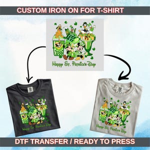 May include: A dark grey and a light grey t-shirt, each displaying a St. Patrick's Day design. The graphic includes cartoon characters, green elements, and the words "Happy St. Patrick's Day". The image also shows a design for a custom iron-on for t-shirts.