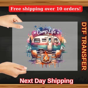 May include: A watercolor illustration of a camper van with the text "Camp Life" in a heart-shaped design. The camper van is parked in front of a campfire with two chairs. The illustration is in shades of blue, green, pink, and orange.