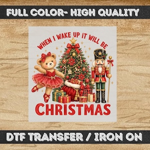 May include: A DTF transfer featuring a teddy bear in a red tutu, a decorated Christmas tree, and a nutcracker soldier. The text reads "WHEN I WAKE UP IT WILL BE CHRISTMAS". The design includes wrapped gifts and gold stars on a light background.