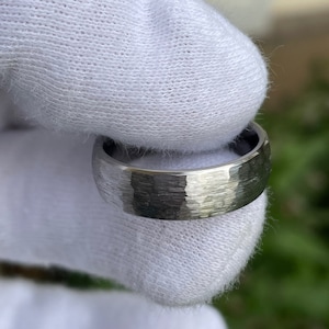 May include: A silver wedding band with a hammered finish.