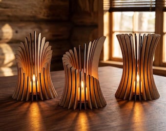 Peut inclure: Trois bougeoirs en bois avec un design en forme d'éventail, chacun contenant une bougie allumée. Les supports sont en bois clair et reposent sur une table en bois foncé. La lueur chaleureuse des bougies crée une atmosphère chaleureuse.