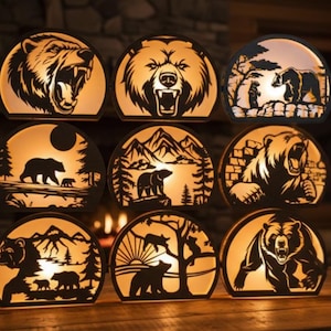 May include: Nine decorative bear-themed lamps with a warm, glowing light. Each lamp features a unique silhouette design of bears in various poses, including roaring and walking. The lamps are arranged on a wooden surface.