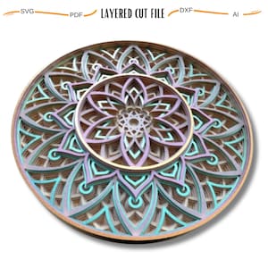 May include: A layered mandala design with intricate details, featuring a gradient of teal, purple, and gold colors. The mandala is cut from wood and has a circular shape.