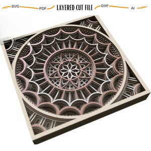 May include: A layered cut file design featuring a circular mandala pattern with intricate details. The design is made up of multiple layers of wood, creating a 3D effect. The wood is a light brown color with a hint of red.