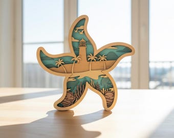 May include: A wooden starfish-shaped art piece with a layered design. The layers depict a coastal scene with a lighthouse, palm trees, and ocean elements in shades of beige, blue, and brown. The artwork is displayed on a light-colored wooden surface.
