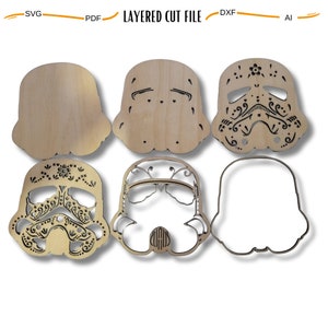 May include: Six layered wooden cutouts of a Star Wars Stormtrooper helmet with a Day of the Dead sugar skull design. The cutouts are in various stages of completion, from a basic outline to a fully detailed design.