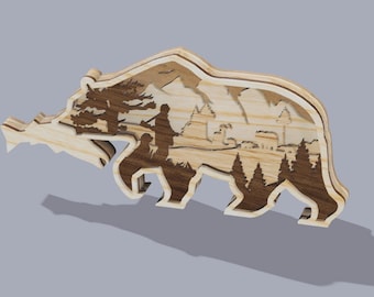 May include: Wooden bear-shaped art piece with a layered design. The artwork features a detailed landscape scene within the bear's silhouette, including trees, mountains, and figures. The piece is made of light and dark wood.