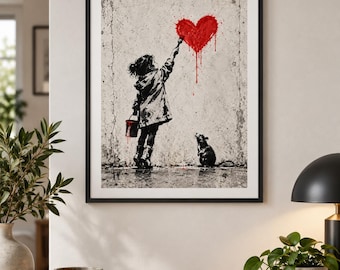 May include: A framed wall art print featuring a black and white illustration of a child in a coat painting a large, dripping red heart on a textured concrete wall, with a small rat standing on the ground looking up at the heart.