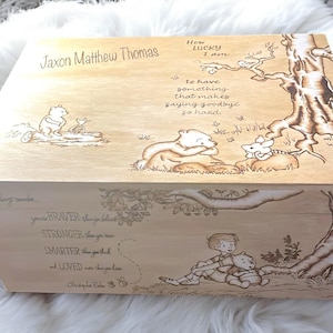 Könnte beinhalten: Holz-Andenkenbox mit eingravierten Winnie-the-Pooh-Illustrationen und Zitaten. Der Deckel trägt den Namen "Jaxon Matthew Thomas" und das Zitat "How lucky I am to have something that makes saying goodbye so hard."