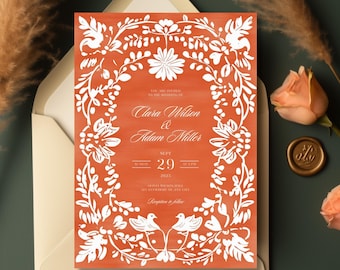 May include: An orange wedding invitation with a white floral design and the text "You are invited to the wedding of Clara Wilson & Adam Miller Sunday Sept 29 at 4:30 PM 2023"