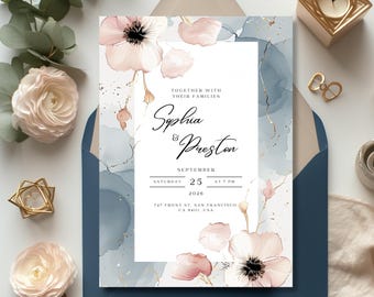 May include: Wedding invitation with a watercolor background in shades of blue and pink. The invitation features a floral design with delicate pink flowers and gold accents. The text reads "Together with their families, Sophia & Preston, September 25, 2020, at 7 PM, 747 Front St. San Francisco, CA 94111, USA."