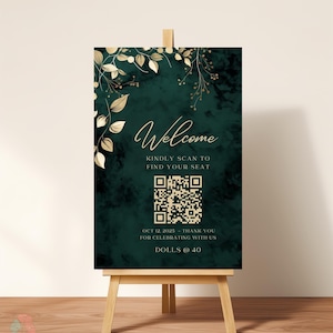 May include: A welcome sign on an easel with a dark green background and gold leaf accents. The sign reads "Welcome" and includes a QR code and event details. The sign is displayed on a wooden easel.