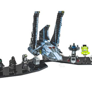 May include: A Lego Star Wars set featuring a large spacecraft with articulated wings, minifigures, and additional vehicles. The set includes 169 pieces. The spacecraft is primarily grey and blue.