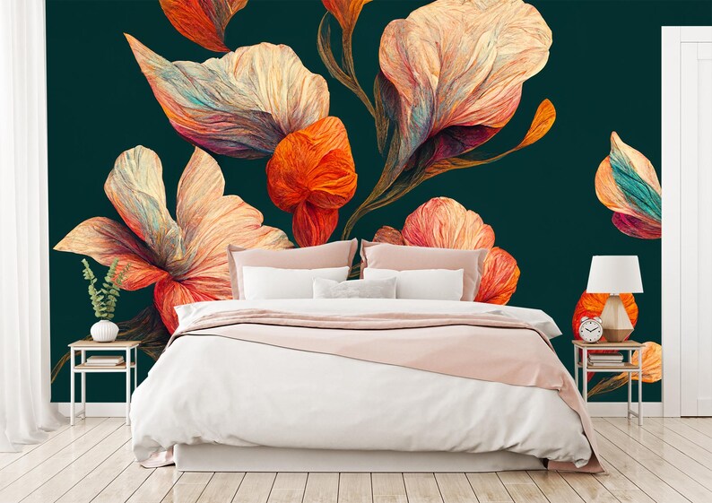 May include: A bedroom with a large floral mural in shades of orange, peach, and white against a dark teal background. The bed has white linens, a pink throw, and pillows. A small side table with a lamp and a clock is on the right.