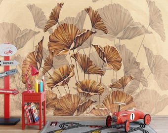 Op de afbeelding: Een kamer met een groot bloemenbehang in bruin- en beigetinten. Een rode bijzettafel met boeken, potloden en een lamp staat naast een rode speelgoedauto. Een grijs tapijt met een racebaanontwerp ligt op de vloer.