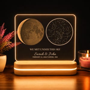 May include: A rectangular acrylic light panel set in a wooden base, featuring an illuminated moon graphic and a star constellation map. The text reads: WE MET UNDER THIS SKY, Sarah & John, FEBRUARY 13, 2026 FLORIDA, USA, in white lettering.