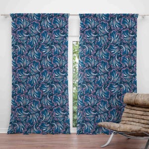 May include: Two matching blue curtains with a repeating pattern of stylized, swirling floral designs in shades of blue, white, and pink. The curtains are hanging in front of a window, with a glimpse of the outdoors visible.