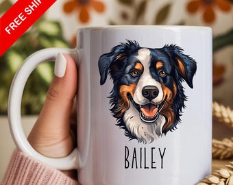 Peut inclure: Un mug en céramique blanche orné d'une illustration colorée du visage d'un chien berger australien au pelage noir, blanc et feu. Sous l'illustration du chien, le nom BAILEY est imprimé dans une police simple en lettres capitales noires.