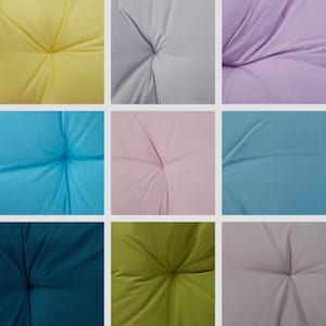 Op de afbeelding: Negen stofstalen in verschillende kleuren, elk met een knoopvormig detail in het midden. De kleuren zijn geel, grijs, lavendel, lichtblauw, roze, blauw, teal, groen en lichtroze.