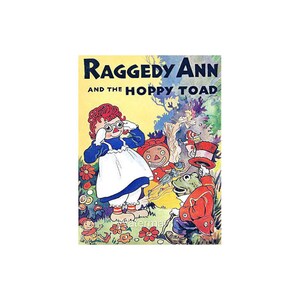 May include: Vintage book cover illustration titled "Raggedy Ann and the Hoppy Toad." The image features Raggedy Ann in a blue dress and white apron, with other whimsical characters like a frog in a red coat and a top hat. The background includes flowers and trees.