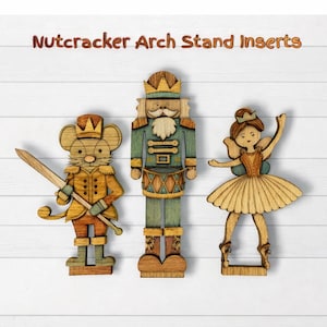 May include: Wooden Nutcracker Arch Stand Inserts. The set includes a mouse soldier with a sword, a nutcracker soldier, and a ballerina. The figures are painted in shades of brown, green, and gold. The text "Nutcracker Arch Stand Inserts" is at the top.