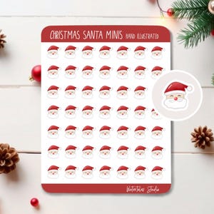 May include: Sheet of Christmas Santa Claus mini stickers. Each sticker features a smiling Santa face with a red hat and white beard. The sheet has the text "Christmas Santa Minis Hand Illustrated" and "Watertales Studio".