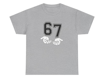 May include: A heather gray t-shirt featuring the number 67 in a bold, black font with a white outline. Below the number are two open hands in a gesture of offering or support. The design is centered on the shirt.