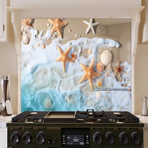 May include: A kitchen backsplash with a beach scene featuring seashells and starfish on a sandy beach with blue ocean waves.