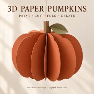 Könnte beinhalten: Ein 3D-Papierkürbis mit orangefarbenen, gewellten Segmenten, einem braunen Stiel und einem grünen Blatt. Der Text 3D PAPER PUMPKINS PRINT • CUT • FOLD • CREATE und Assembly mockup • Digital download ist in dunkelbrauner Schrift zu sehen.