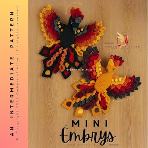 May include: Two handmade crochet phoenixes in vibrant colors of red, orange, yellow, and black. The phoenixes are displayed on a wooden surface. The text "MINI embrys the phoenix" is at the bottom. The text "AN INTERMEDIATE PATTERN" is on the left side.