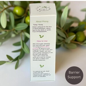 May include: A white product box with text about "Phizog" and instructions for use. The box includes the text "Berry Berry FruitTea Oil Serum." The background features green leaves and berries.