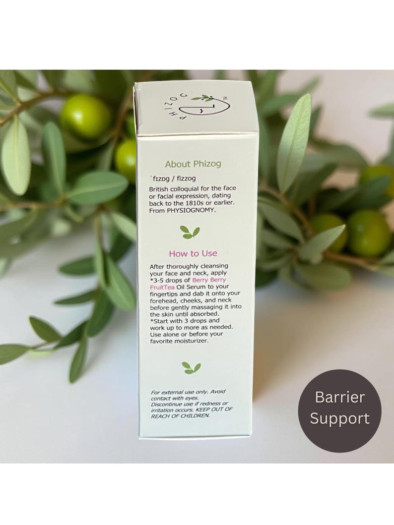 May include: A white product box with text about "Phizog" and instructions for use. The box includes the text "Berry Berry FruitTea Oil Serum." The background features green leaves and berries.
