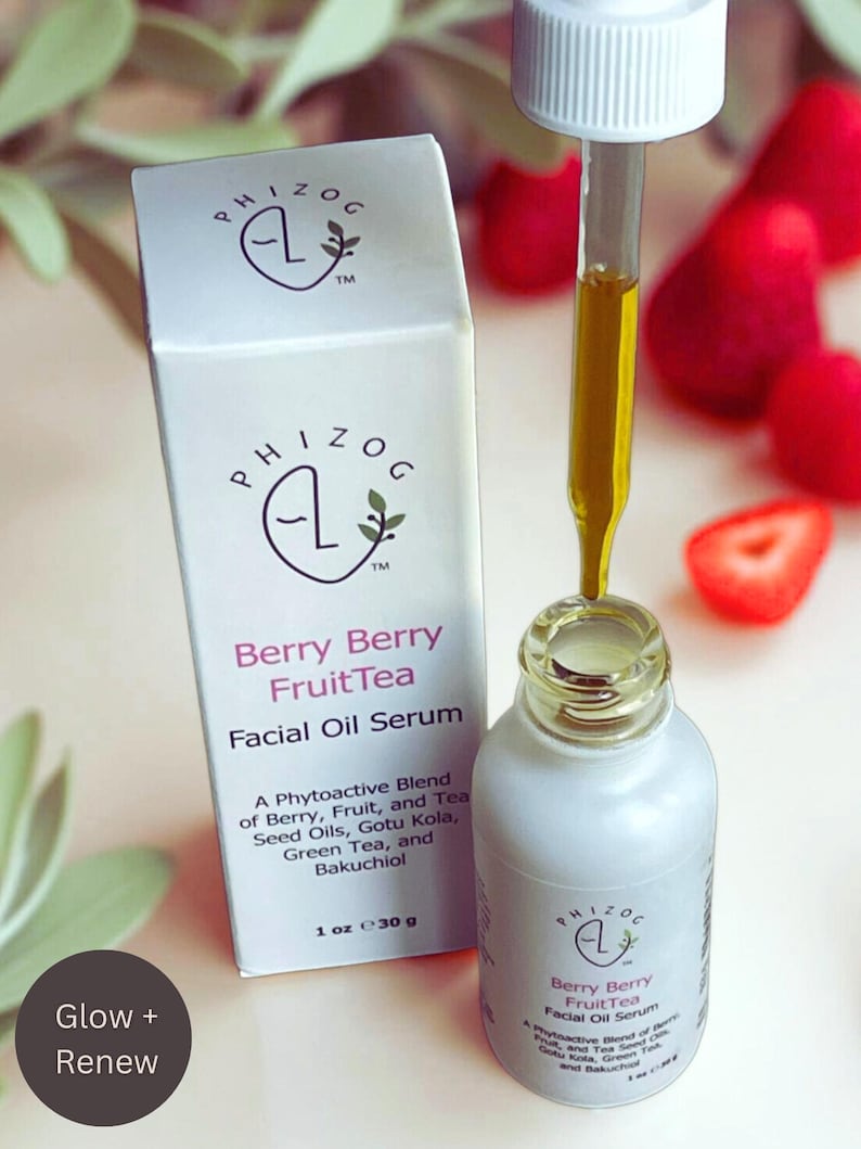 May include: A white bottle and box of Berry Berry FruitTea Facial Oil Serum. The bottle has a dropper filled with yellow oil. The box and bottle have the brand name and product information. The image also includes strawberries.