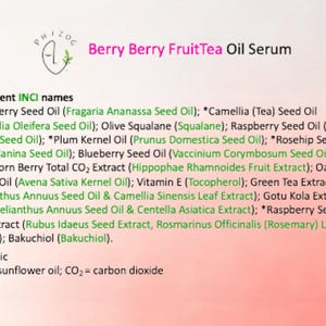 May include: A product label for "Berry Berry FruitTea Oil Serum" lists ingredients including Strawberry Seed Oil, Raspberry Seed Oil, and Vitamin E. The label is on a gradient pink background with the brand logo at the top.