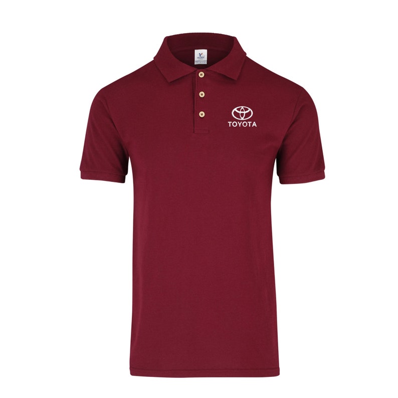 May include: A maroon polo shirt with a white Toyota logo and the word "TOYOTA" embroidered on the chest.