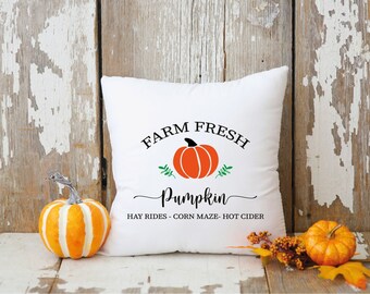 May include: White cushion with the text "FARM FRESH Pumpkin HAY RIDES - CORN MAZE - HOT CIDER" and a graphic of an orange pumpkin with green leaves.