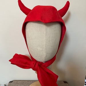 May include: Red devil costume hat with horns and a matching red bow tie.