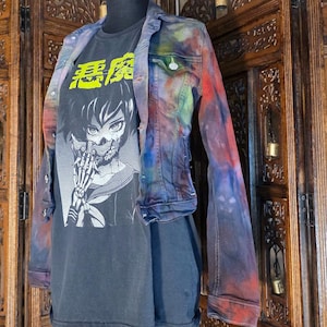 May include: A long-sleeve denim jacket with a multi-colored tie-dye pattern in shades of red, blue, and purple, worn over a dark gray t-shirt featuring a black and white anime-style graphic of a character with a skeletal hand and yellow text.