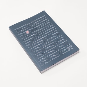 Könnte beinhalten: Ein dunkelblaues Notizbuch mit einem weißen Wellenmuster und einer rosa Quallenillustration. Der Text "3Y" ist in Weiß in der unteren rechten Ecke aufgedruckt. Das Notizbuch ist rechteckig und minimalistisch gestaltet.