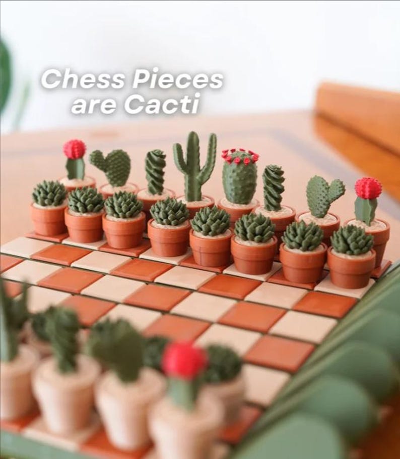 K&ouml;nnte beinhalten: Ein einzigartiges Schachspiel mit kaktusf&ouml;rmigen Figuren in kleinen Terrakottat&ouml;pfen. Das Schachbrett hat ein rot-cremefarbenes Karomuster. Der Text "Chess Pieces are Cacti" ist oben im Bild zu sehen.