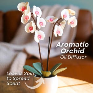 Może przedstawiać: Dyfuzor olejków Aromatic Orchid w białej ceramicznej doniczce. Orchidea ma białe płatki z różowymi środkami i zielone liście. Na zdjęciu widnieje napis "Aromatic Orchid Oil Diffuser" oraz "Leaves Spin to Spread Scent".