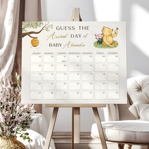 Può includere: Un gioco per baby shower a tema Winnie the Pooh con un calendario per indovinare il giorno di arrivo di Baby Alexandra. Il calendario è decorato con un alveare e un'illustrazione di Winnie the Pooh e Piglet.