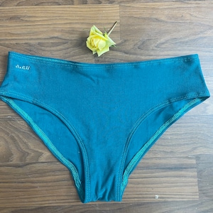 May include: Teal blue underwear with a green trim and the text "a.e.u" on the front.