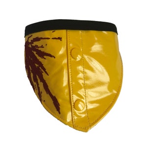 Puede incluir: Collar de perro amarillo con ribete negro y diseño de salpicaduras rojas. El collar tiene dos botones a presión amarillos.