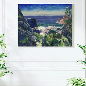 Può includere: Dipinto a olio di un paesaggio costiero con cielo blu e mare. L'opera presenta rocce blu scuro, fogliame verde e onde bianche. Il dipinto è incorniciato e montato su una parete bianca.