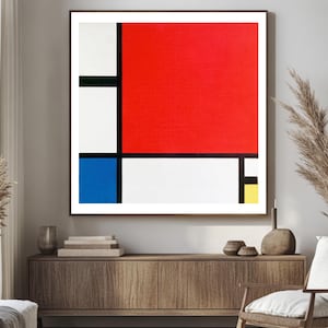 Könnte beinhalten: Ein gerahmter Kunstdruck im abstrakten Stil, der an Mondrian erinnert. Das Kunstwerk zeigt eine kühne Anordnung von roten, weißen, blauen und gelben rechteckigen Formen, die durch schwarze Linien getrennt sind. Der Druck wird in einem Raum mit neutralen Tönen ausgestellt.