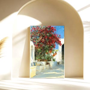 May include: A painting of a white building with a red flowering tree in front of it. The building has a white archway and the tree is in full bloom. The painting is set against a blue sky.
